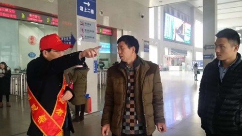 图为市残联志愿者为乘客指引路线